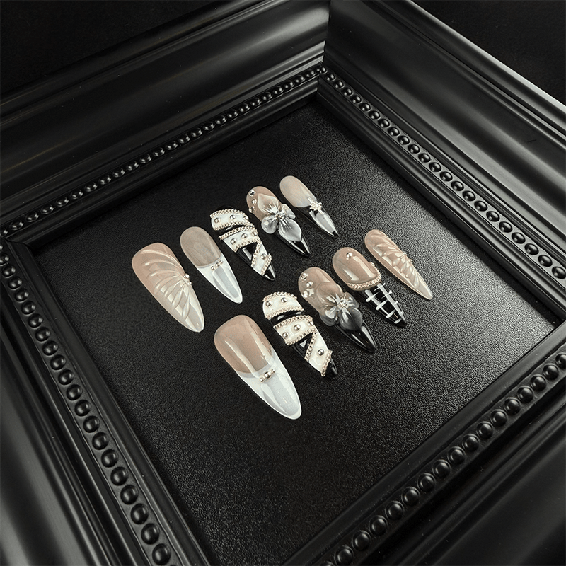 Black and nude press-on nails with 3D flowers and metal studs