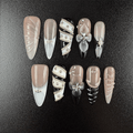 Black and nude almond press-on nails with silver chain details