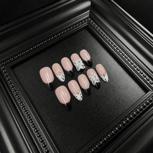 Nude-pink press-on nails with black French tips and white star details