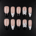 Black and white French tip press-on nails with a 3D pearl bow