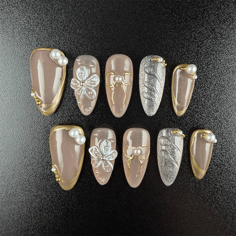 Nude almond press-on nails with gold trim and 3D flowers