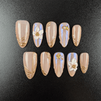 Nude aurora chrome press-on nails with gold lines and white flowers